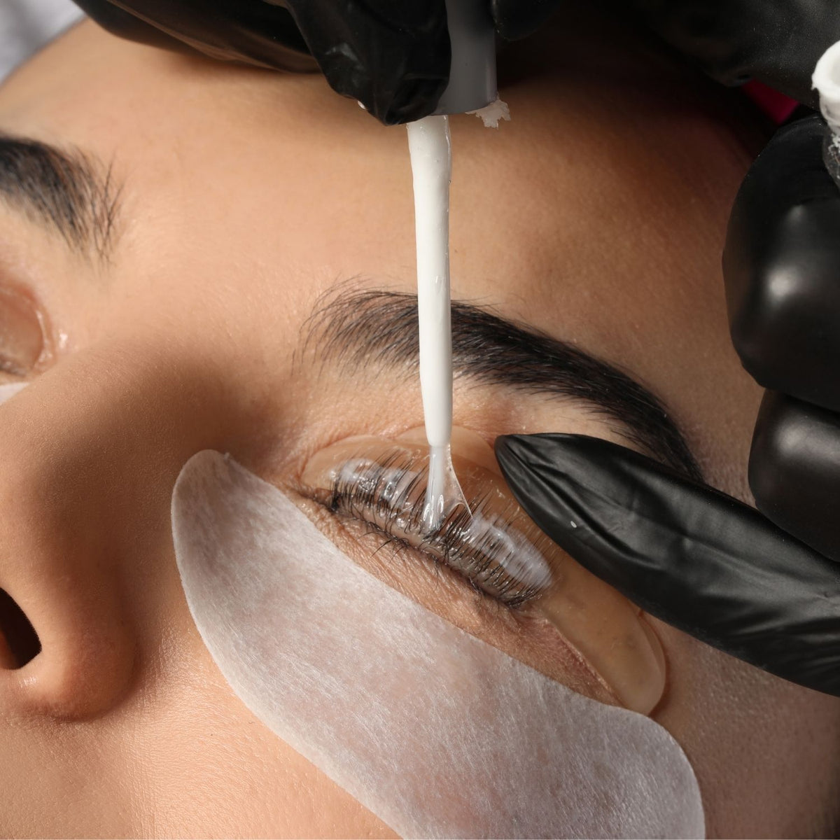 Lash-liftbehandeling: lotion aanbrengen op wimpers op een siliconenpad
